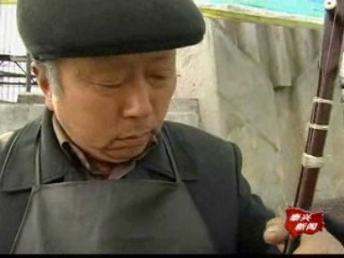 街头拉二胡 修车匠自娱其乐